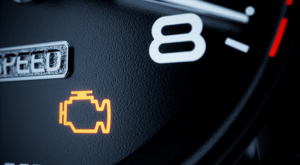 A yellow check engine light is lit up on a car's dash. 