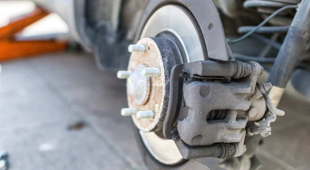 A caliper and rotor are shown on a vehicle during a brake service.