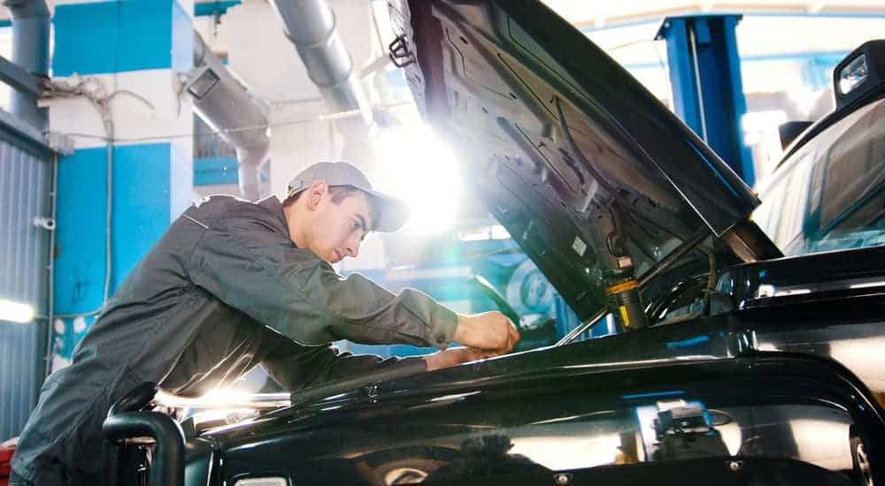 A mechanic is working on a car at a local garage, which is one of the more popular car maintenance locations.