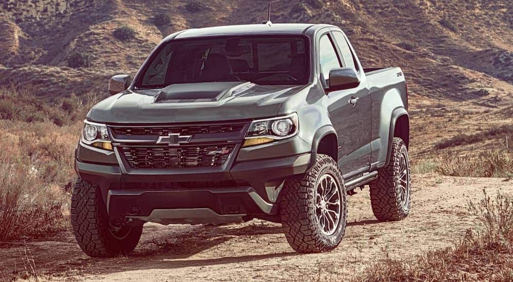 A grey 2019 Chevy Colorado ZR2 is driving on a dirt road while equipped with popular off-road Chevy Parts. 
