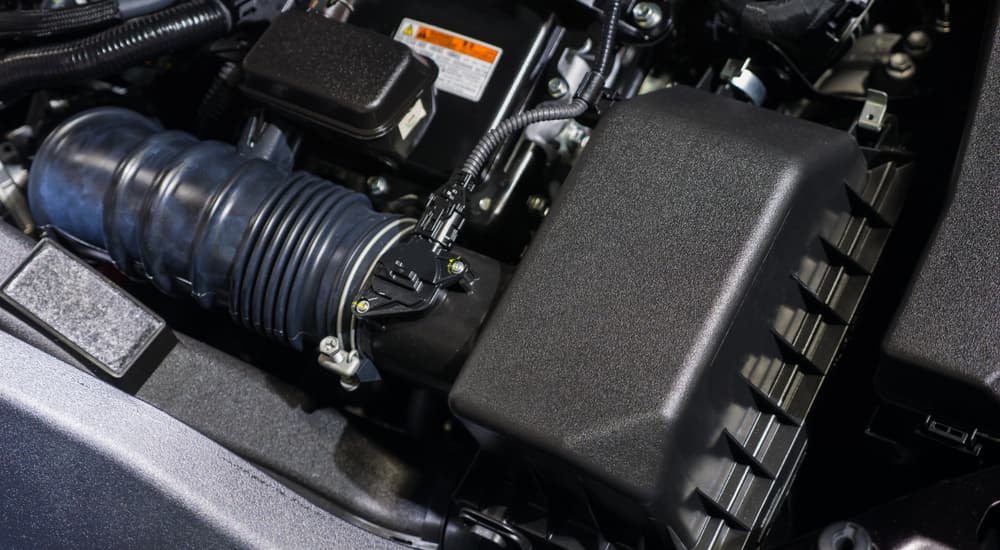 A black air filter box in the engine bay of a car.