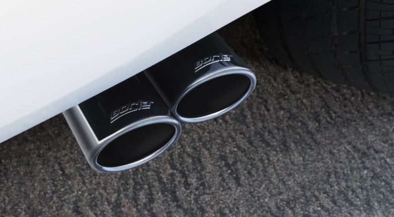 Two chrome tailpipes coming out from the rear bumper of a car.