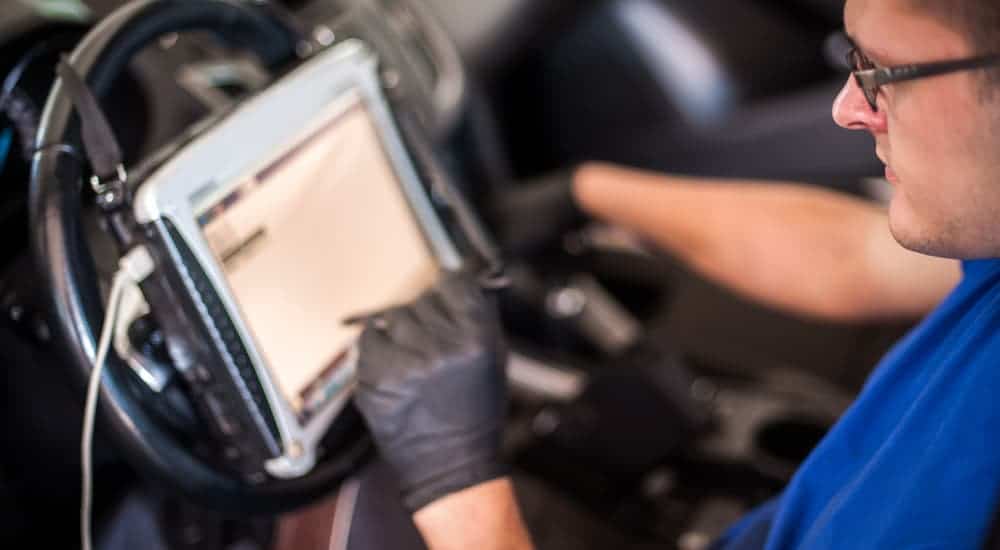 A mechanic is using a tablet program to diagnose the BMW check engine light.