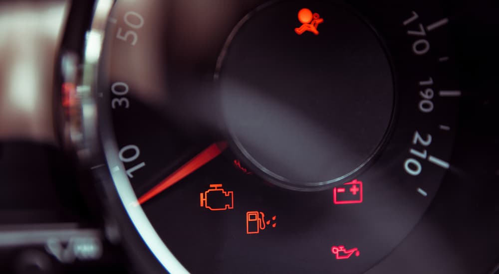Several BMW check engine lights and other warning lights are shown in the speedometer area.
