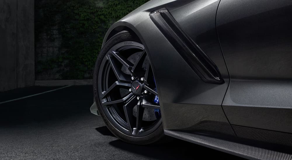 The wheel and front fender on a grey 2019 Chevy Corvette ZR1 are shown in a dark room. 