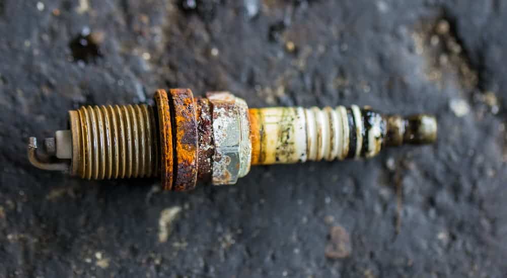 A rusty and corroded spark plug is shown in close up.
