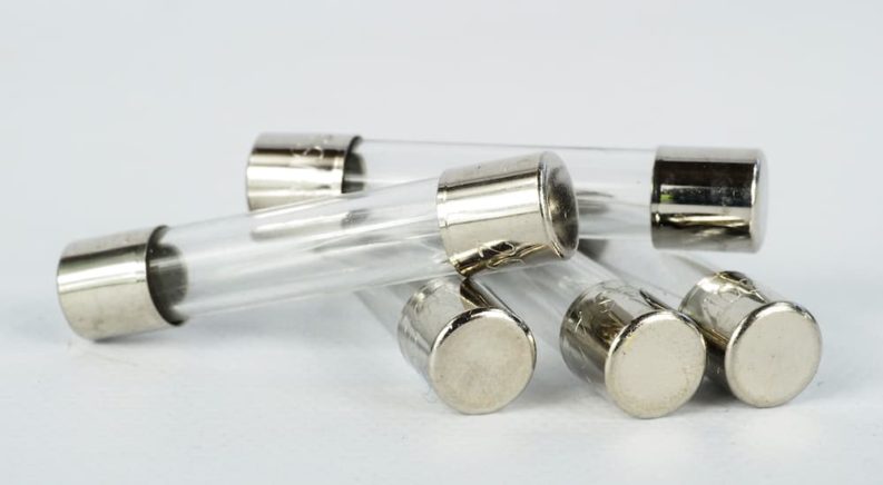 A few clear cylindrical fuses are shown stacked on each other.
