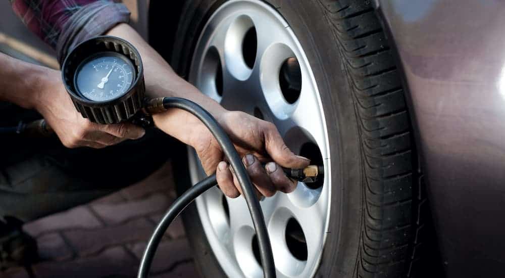 A mechanic is checking the tire pressure at a discount tire shop.