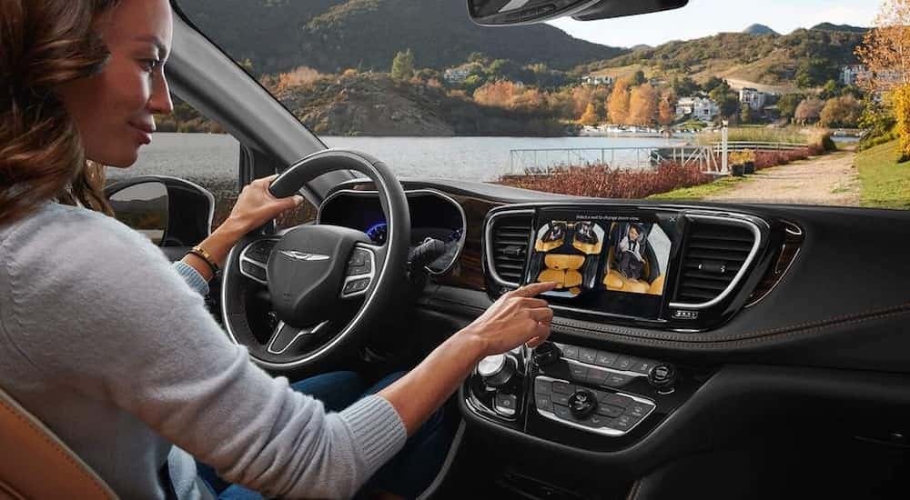 A woman is looking at the camera system in a 2021 Chrysler Pacifica.