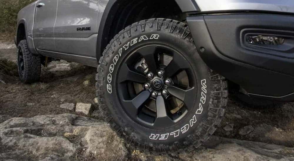 A closeup shows a Goodyear Wrangler tire on a silver 2021 Ram 1500.