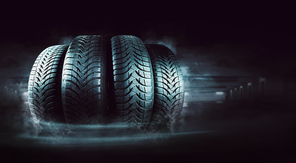 A set of 4 tires are shown with a dark background.