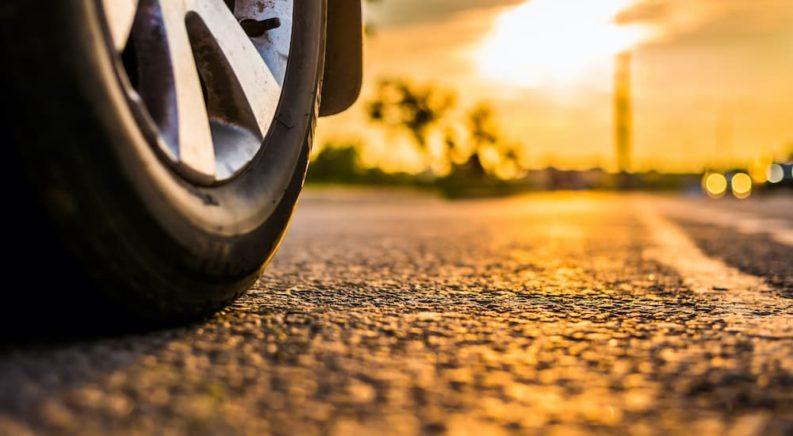 A summer tire is shown on pavement at sunset.