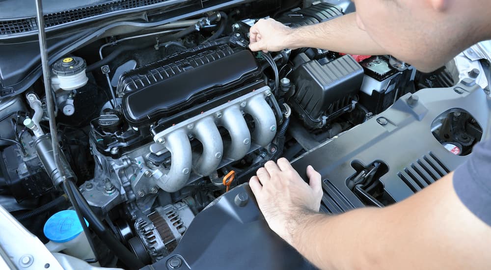 A man is inspecting a car engine.