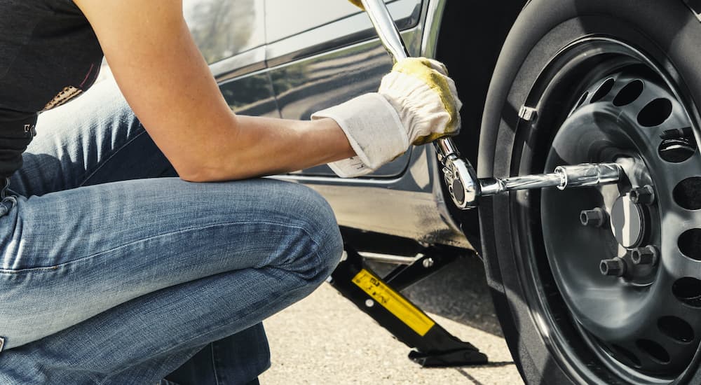 A person is shown tightening the lug nuts on a wheel.