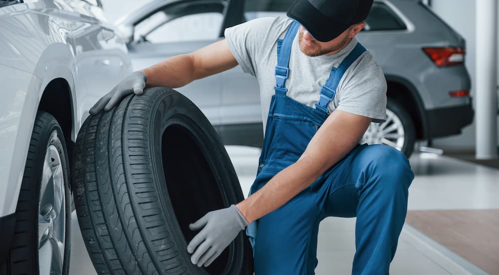 A mechanic is shown inspecting a tire at a tire shop.