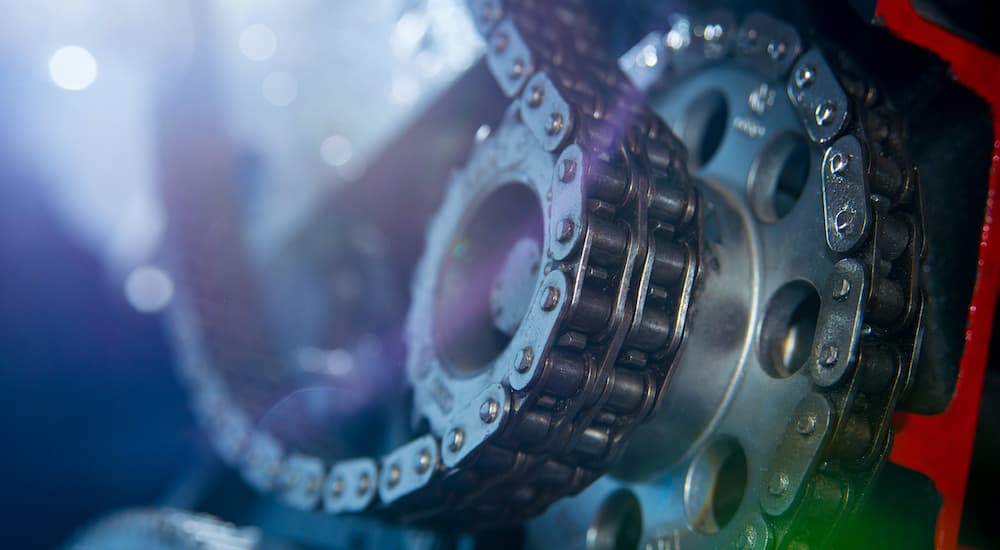 A close up shows a timing chain around a pully.