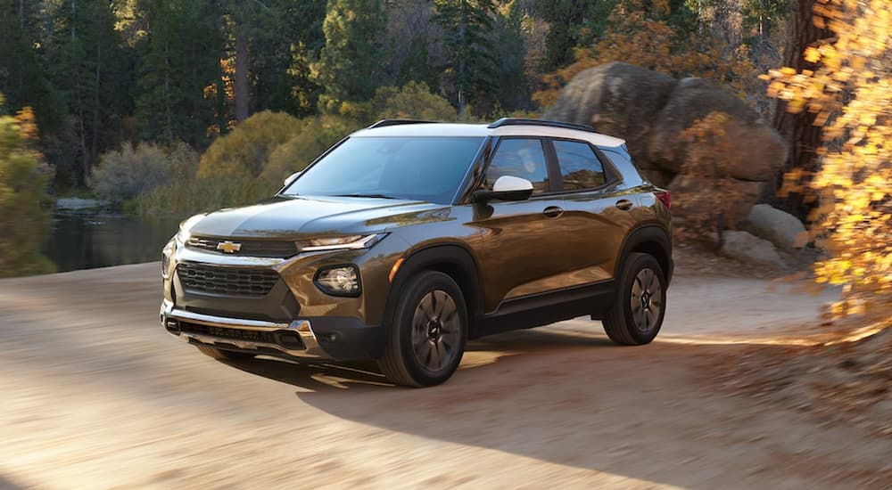 A bronze 2022 Chevy Trailblazer is shown driving on a dirt road.