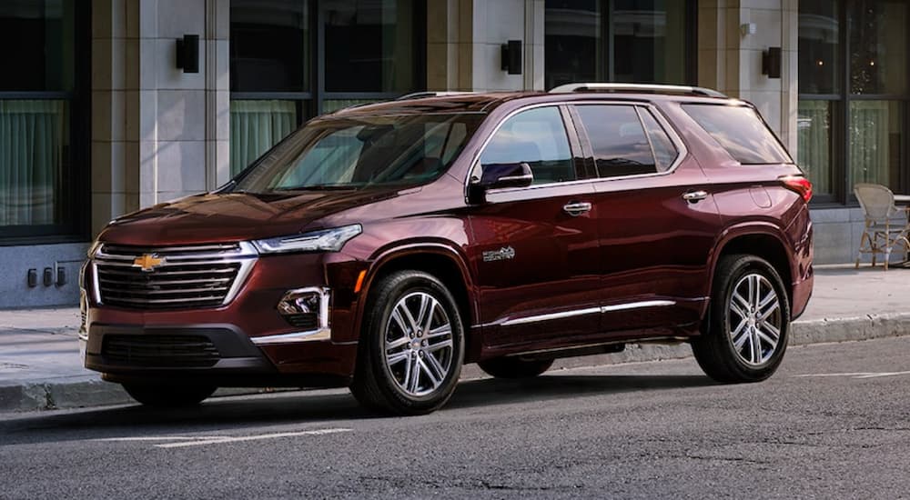 A maroon 2022 Chevy Traverse is shown from the side parked on a city street.