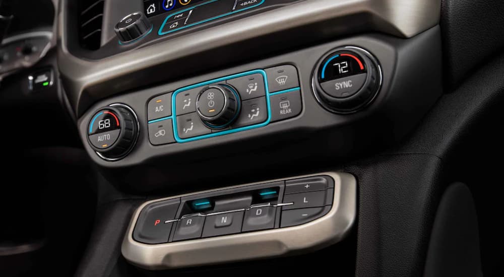 The black interior of a 2022 GMC Acadia shows the heat controls in close up.