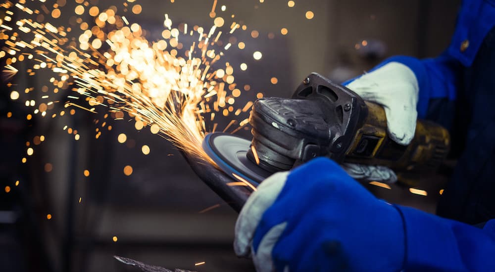 An angle grinder, one of the most popular advanced tools you need for fabrication, is shown kicking up sparks.