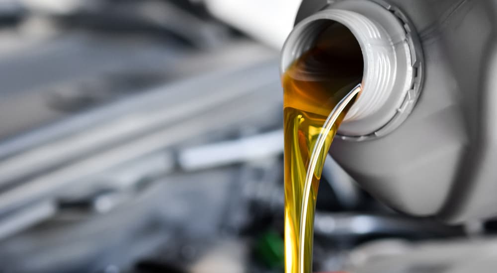 Oil is shown being poured into an engine during a quick oil change.