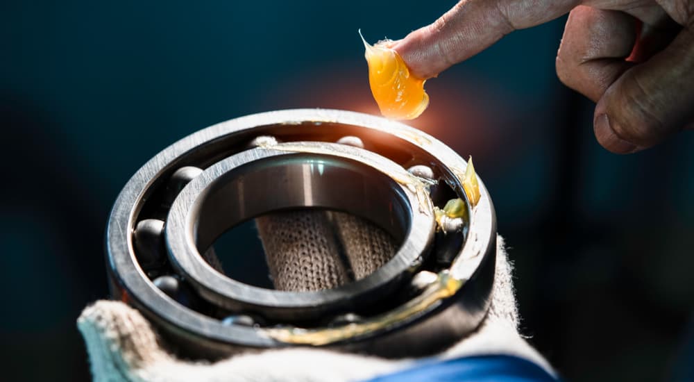 A mechanic is shown putting grease onto a bearing.