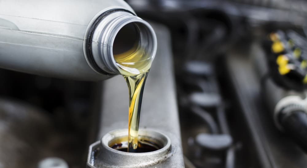 Engine oil is shown being poured during an oil change.