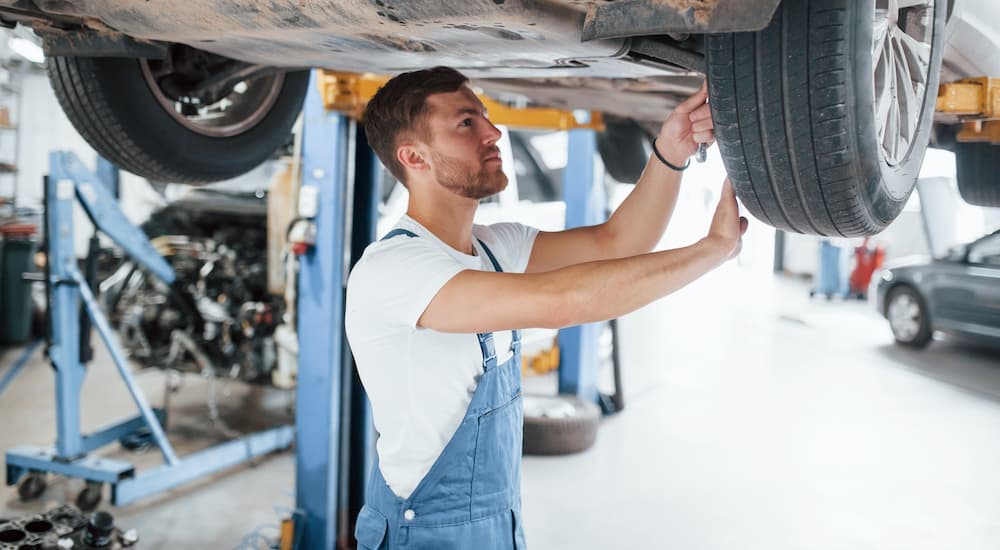 A mechanic is shown checking suspension components during a Ram service near you.