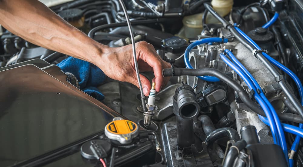 A technician is shown removing a spark plug.