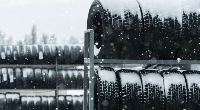Tire racks are shown covered in snow after buying a set of winter tires near you.
