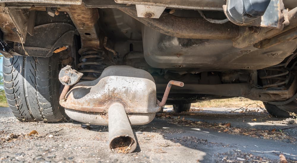 An exhaust is shown touching the ground with broken hangers.