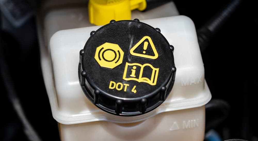 A close up shows the DOT 4 stamp on a reservoir cap.