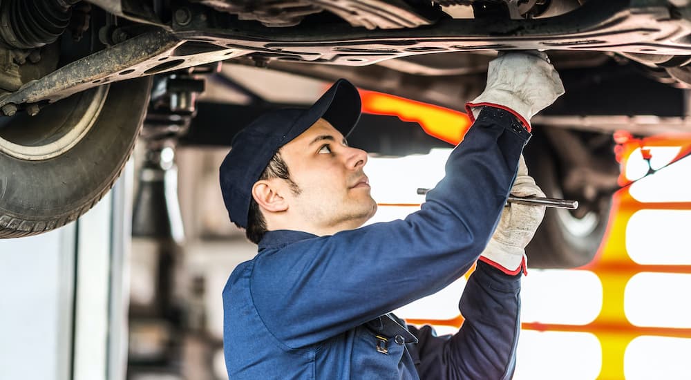 A mechanic is shown working on a catalytic converter.