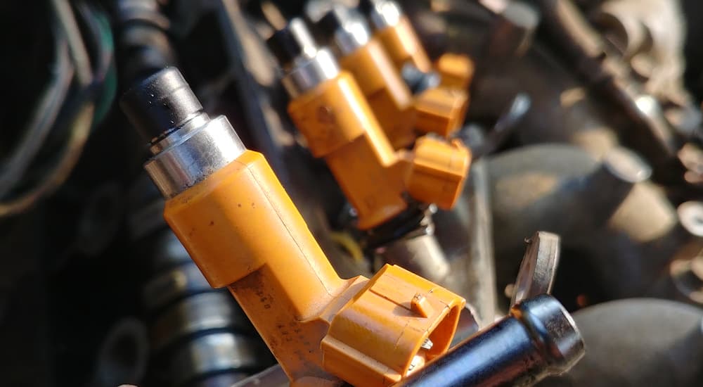 A close up shows a row of yellow fuel injectors.