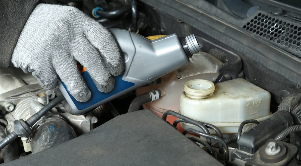 A close up of someone pouring brake fluid is shown.