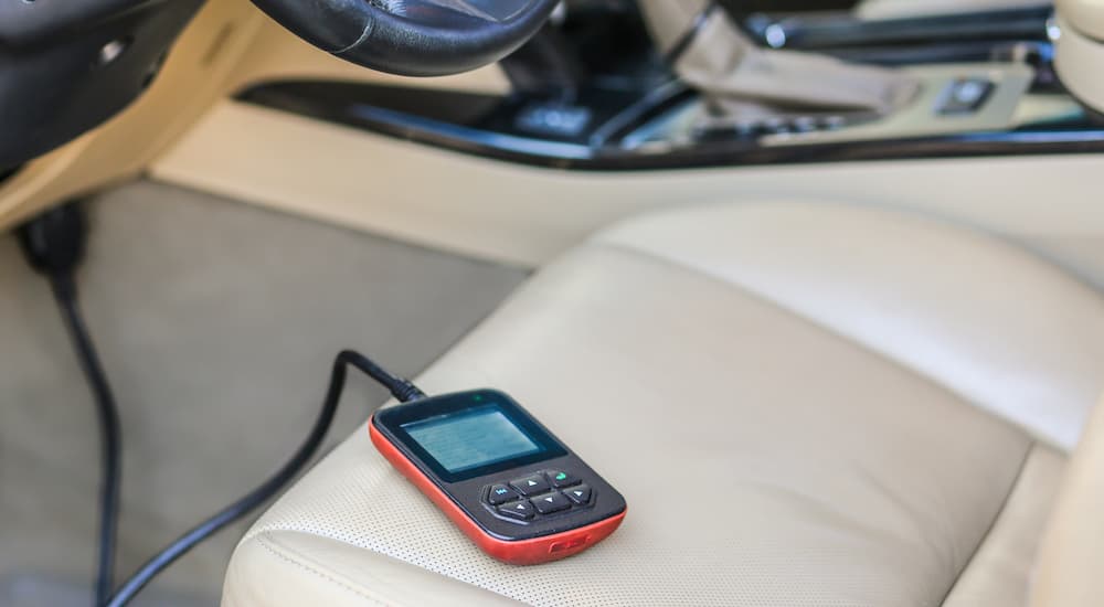 A code reader is shown on the seat of a vehicle.