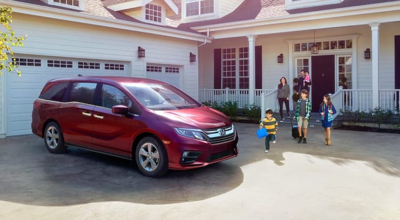 A red 2020 Honda Odyssey is shown parked in a driveway.