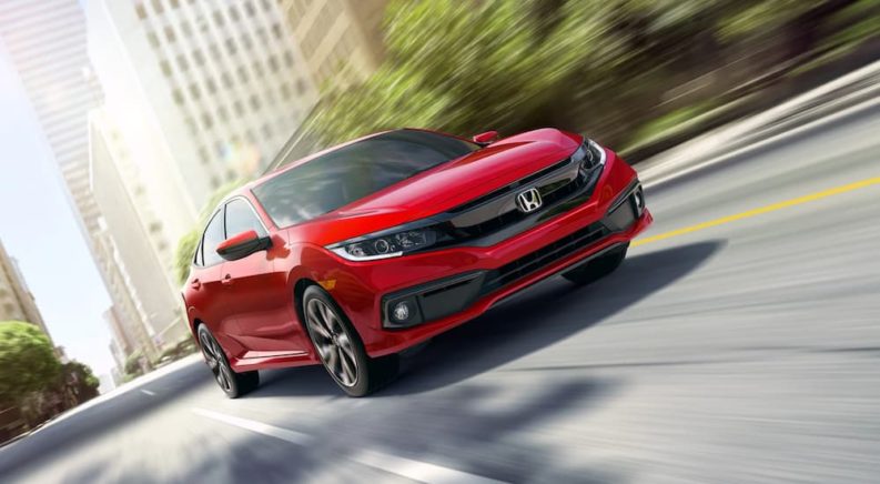 A red 2019 Honda Civic is shown driving on a city street.