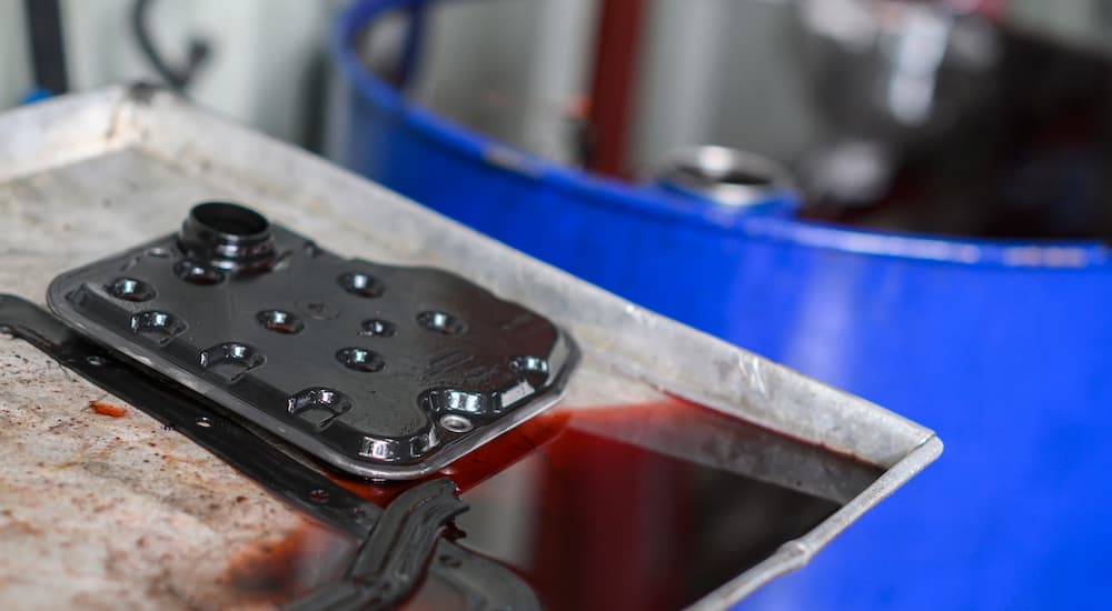 A pan on transmission fluid is shown being prepared for disposal.