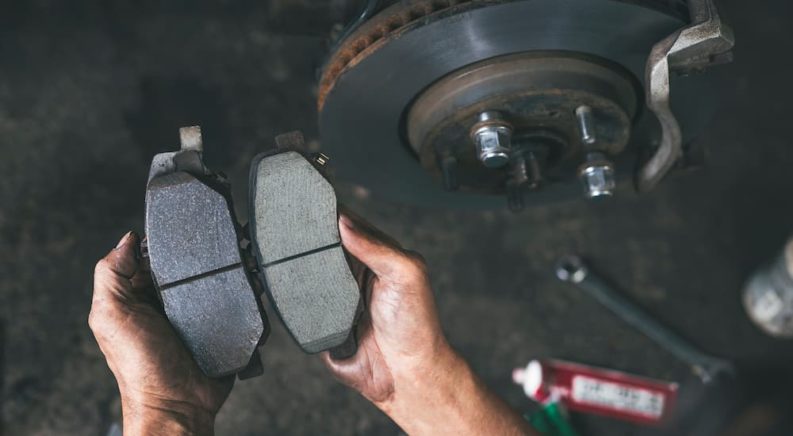 A mechanic is shown holding brake pads.