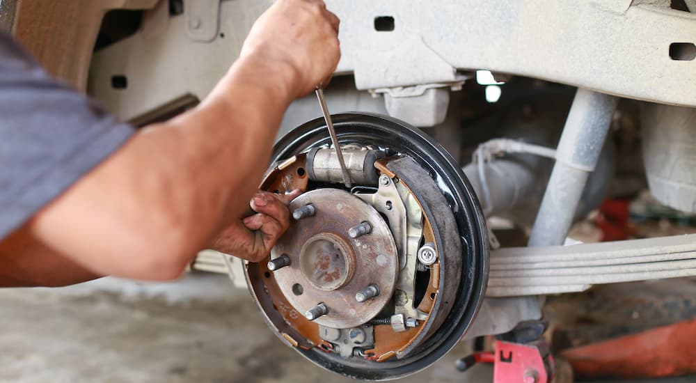 A mechanic is shown inspecting drum brakes.