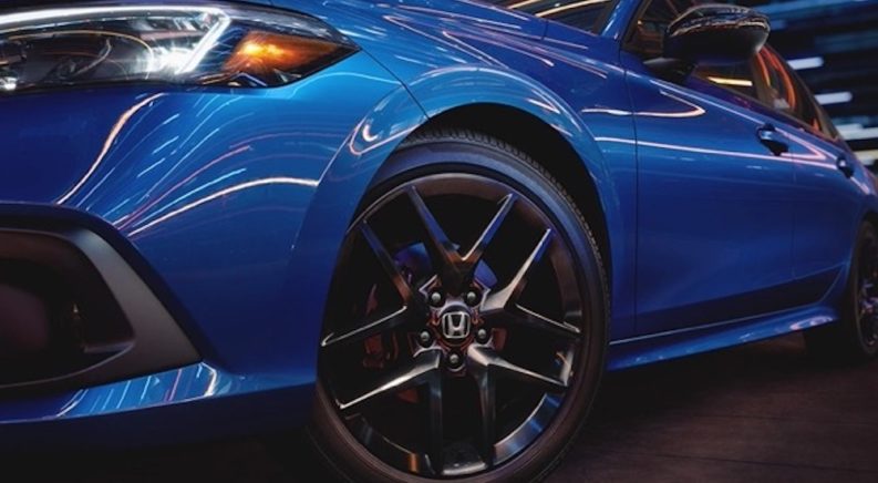 A closeup of a blue 2022 Honda Civic is focused on the wheel.