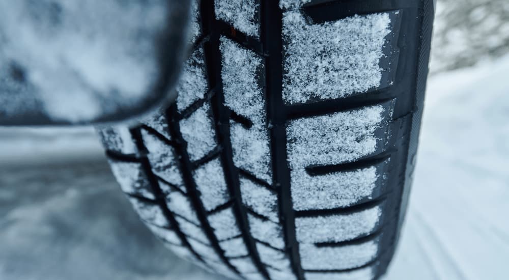 A close up of tire treads covered in snow are shown.