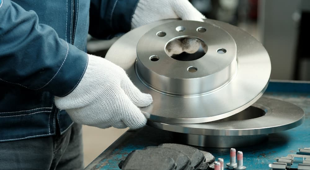 A mechanic is shown holding rotors during a brake service.