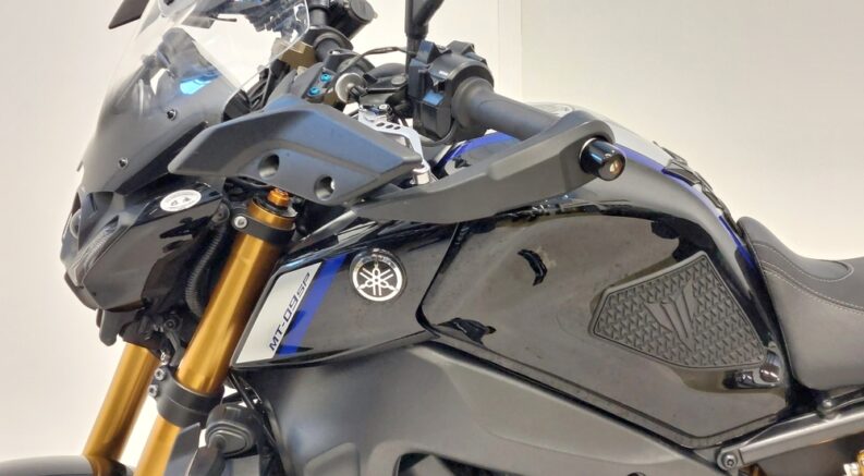 A close-up on the tank of a black 2021 Yamaha MT-09 SP is shown, featuring a grip on the side.