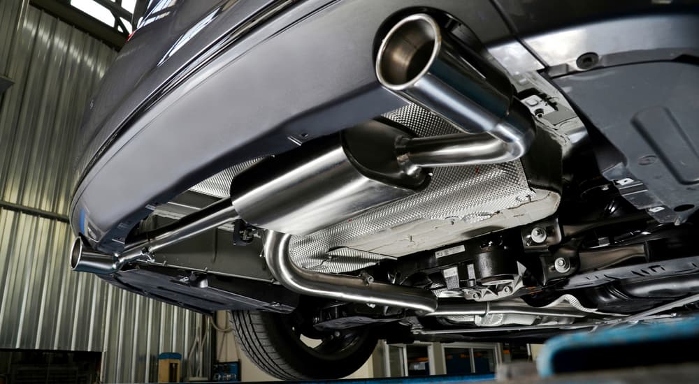 A brand new car exhaust is shown on a vehicle on a lift.