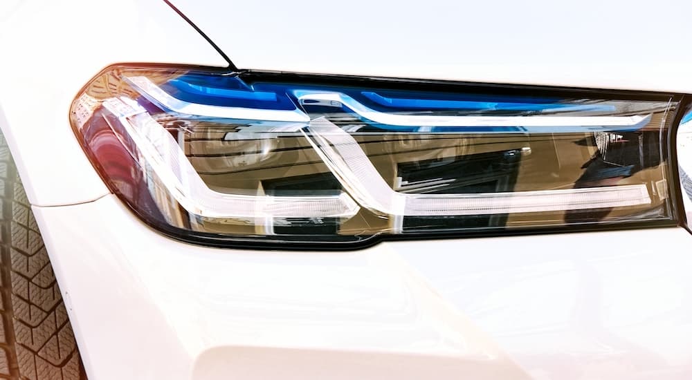 A close up shows a laser headlight on a white vehicle.