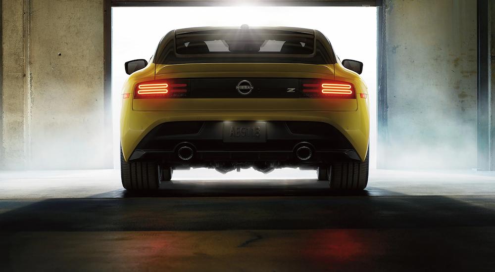 A yellow 2023 Nissan Z is shown from the rear while parked in a garage after receiving Nissan service.