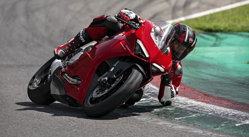 A red 2023 Ducati Panigale V2 is shown from the front while cornering.