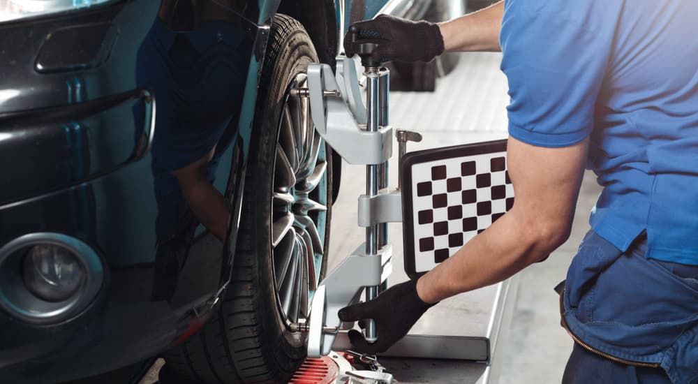 A mechanic is shown performing a tire alignment.